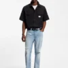 Blaue, konisch geschnittene Jeans aus Distressed-Denim Blaue, konisch geschnittene Jeans aus Distressed-Denim