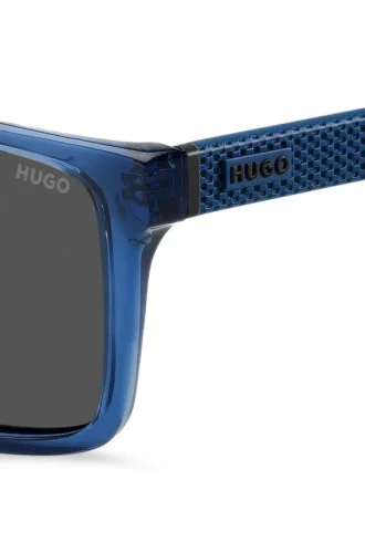 Transparent-blaue Sonnenbrille mit gemusterten Bügeln